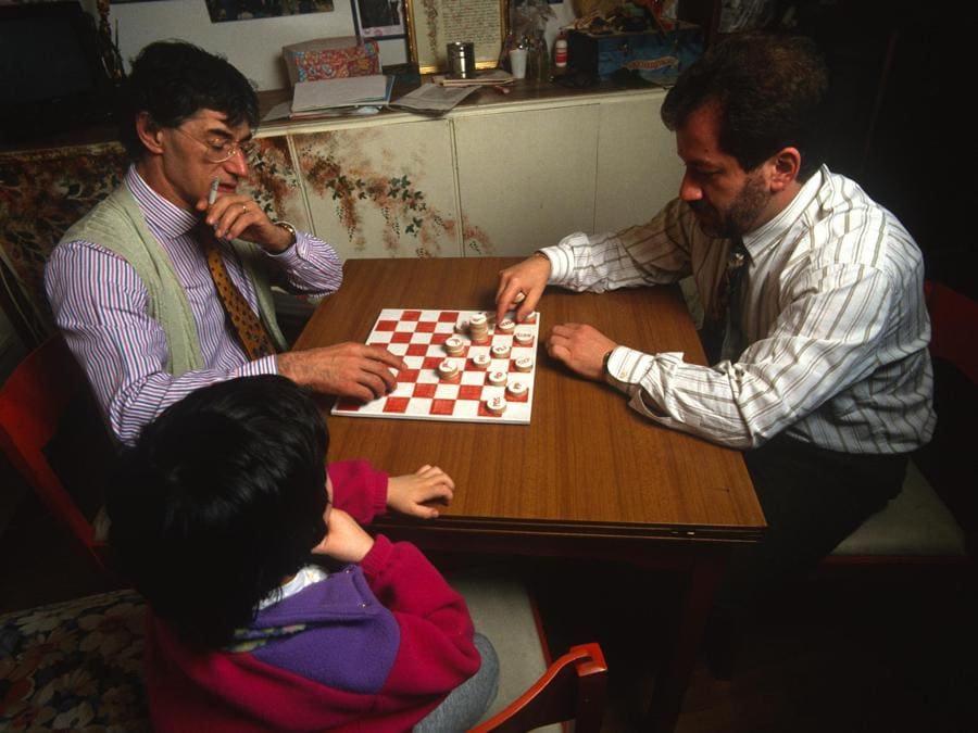 Renzo Bossi osserva suo padre Umberto (s) e Roberto Maroni mentre giocano a dama nella casa di Gemonio a metà anni novanta. (Ansa / Mauro Vallinotto) 