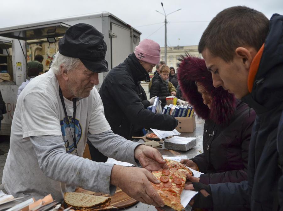 Volontari britannici consegnano fette di pizza alla gente del posto, a Kherson, nel sud dell’Ucraina. EPA/IVAN ANTYPENKO