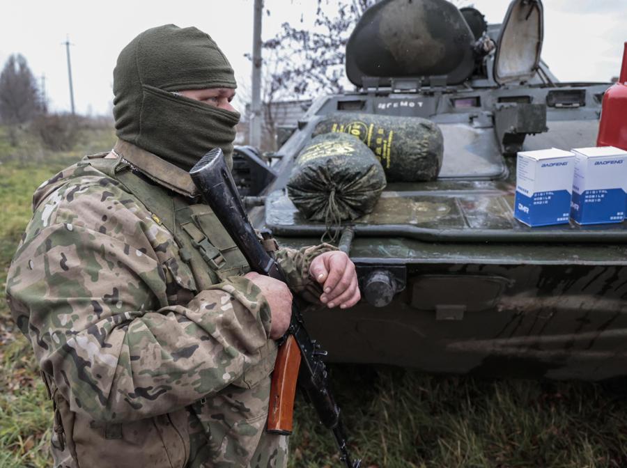 Un membro dell’autoproclamata milizia della Repubblica popolare di Donetsk (DPR) si trova vicino a un veicolo corazzato anfibio BTR-80 8×8 mentre riceve aiuti umanitari da volontari russi in una posizione non lontana da Avdeevka, nella regione di Donetsk , Ucraina orientale. EPA/ALESSANDRO GUERRA