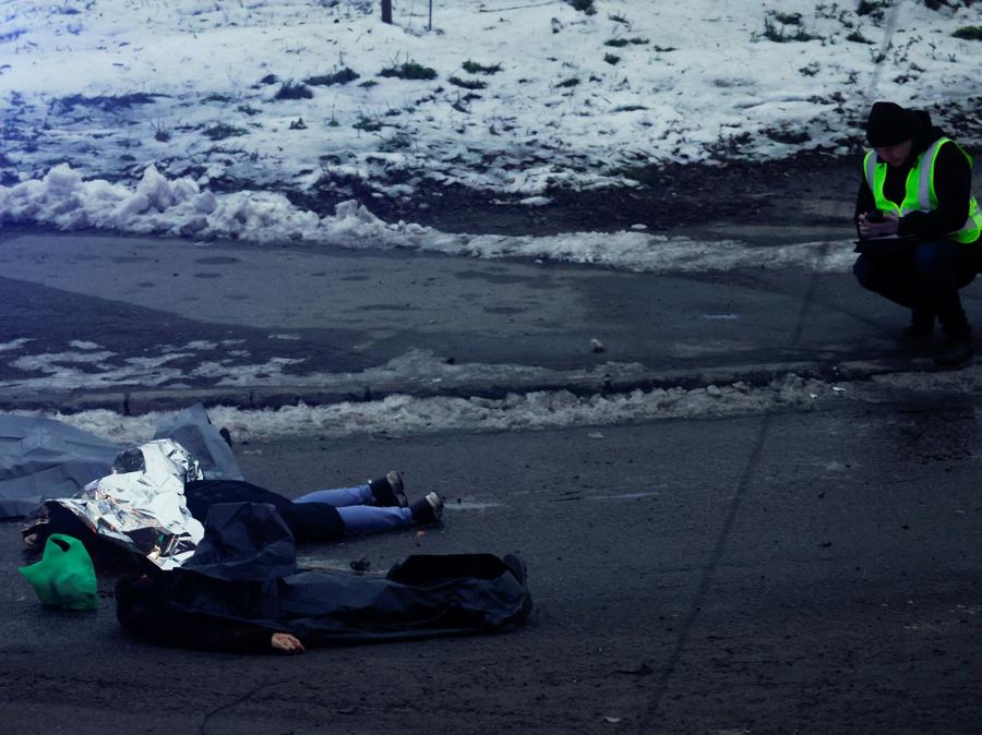  Un agente di polizia si accovaccia accanto ai cadaveri in un luogo di un attacco missilistico russo, durante l’attacco della Russia all’Ucraina, a Kiev. REUTERS/Valentyn Ogirenko