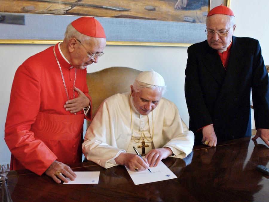Papa Benedetto XVI scrive un documento in Vaticano il 20 aprile 2005 mentre è affiancato dal cardinale italiano Angelo Sodano (destra)  e dallo spagnolo Eduardo Martinez Somalo. Papa Benedetto XVI si è mosso rapidamente nel primo giorno del suo regno mercoledì per dissipare i timori di un papato rigido e autoritario, dicendo che avrebbe lavorato per il dialogo sia all’interno della Chiesa che con le altre fedi.  (Reuters/Osservatore Romano CLH/DL)