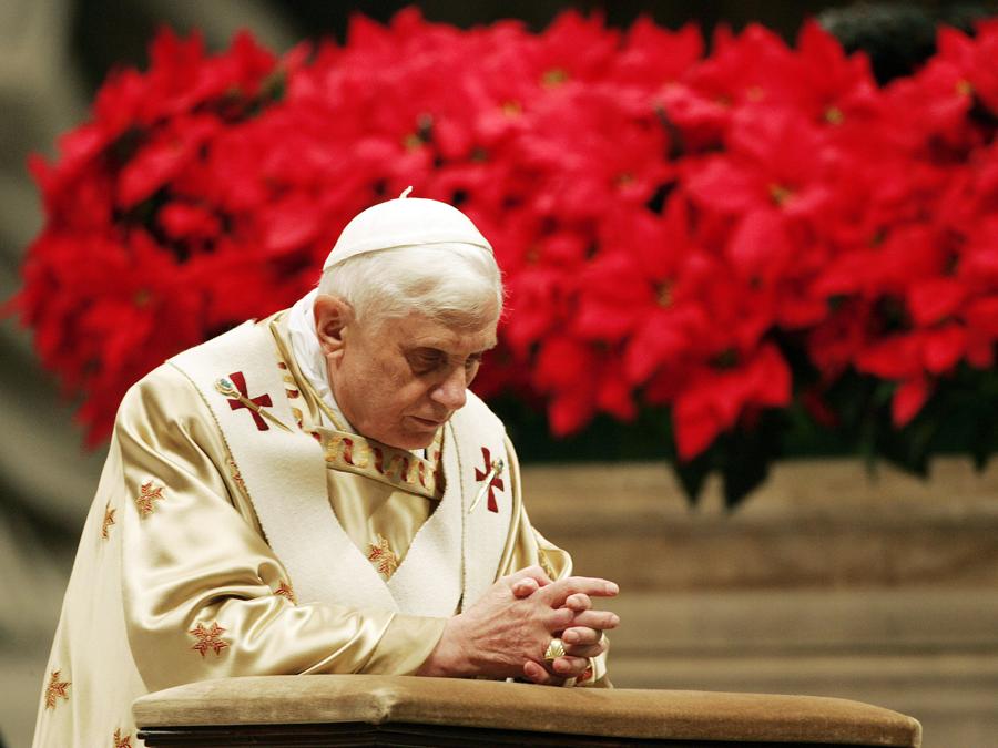 Papa Benedetto XVI si inginocchia mentre celebra la messa di mezzanotte nella Basilica di San Pietro in Vaticano il 25 dicembre 2006. REUTERS/Alessandro Bianchi (VATICAN)