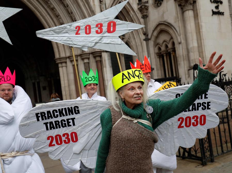 18 dicembre 2018 la stilista britannica Vivienne Westwood, vestita da angelo, posa con altri attivist davanti alla Royal Courts of Justice , l’Alta Corte britannica, nel centro di Londra. (Photo by Adrian DENNIS / AFP)