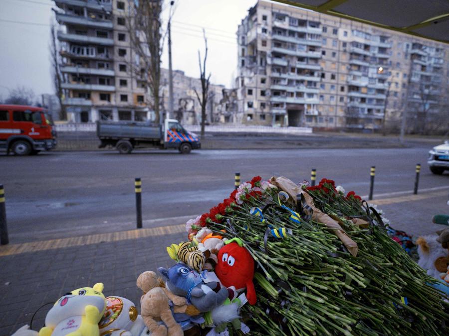 Fiori e giocattoli vengono collocati alla fermata dell’autobus di fronte a un edificio residenziale nella città ucraina di Dnipro, distrutto a seguito di un attacco missilistico. (Photo by Vitalii Matokha / AFP)