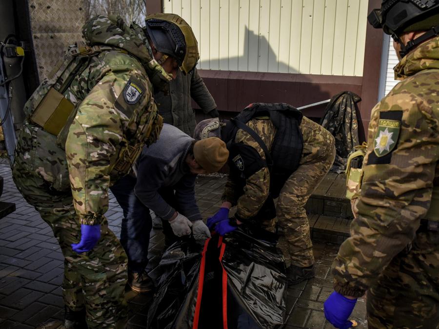 Membri dell’unità di polizia White Angels si preparano a spostare i resti di una persona morta durante i bombardamenti a Bakhmut, Ucraina orientale. EPA/OLEG PETRASYUK