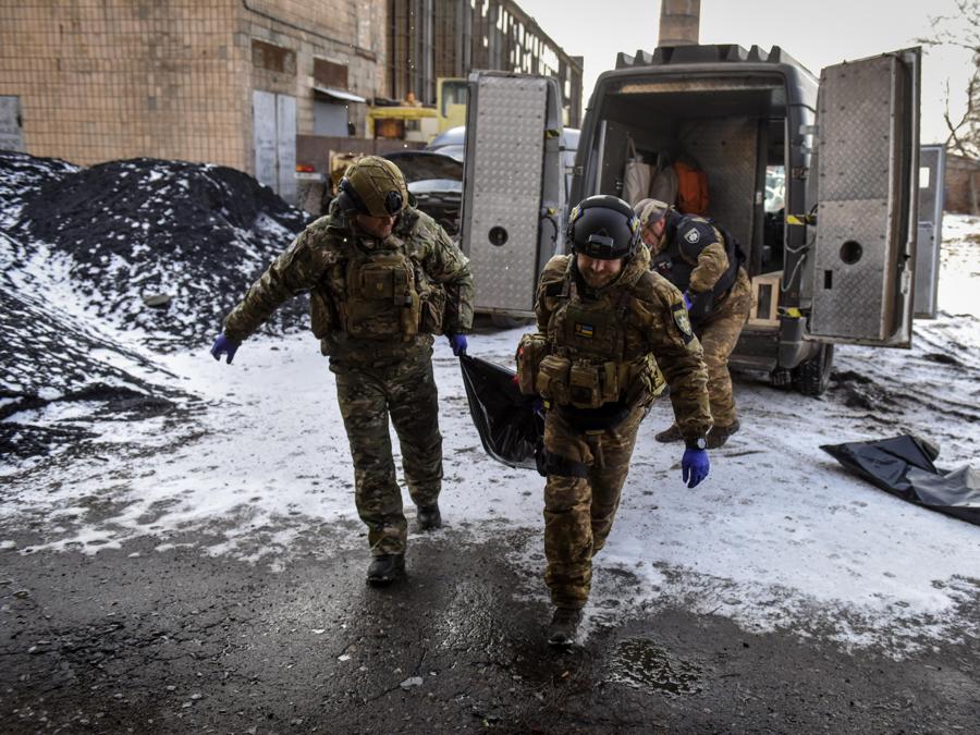 Membri dell’unità di polizia degli Angeli bianchi spostano i resti di una persona morta durante i bombardamenti a Bakhmut, Ucraina orientale. EPA/OLEG PETRASYUK