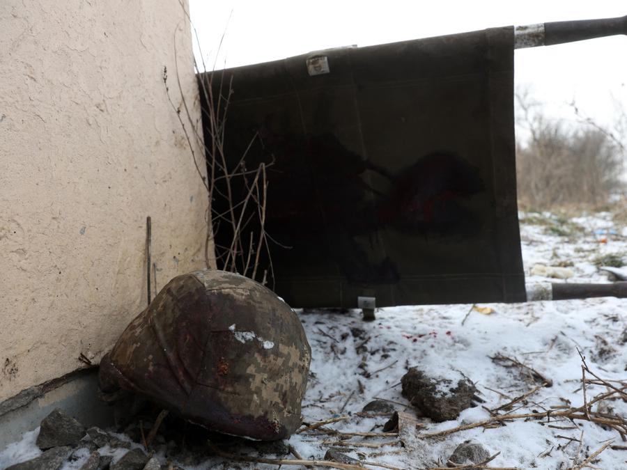 Una barella insanguinata e un elmetto militare sul terreno innevato, nella città ucraina di Bakhmut, nella regione di Donetsk. (Photo by Anatolii Stepanov / AFP)