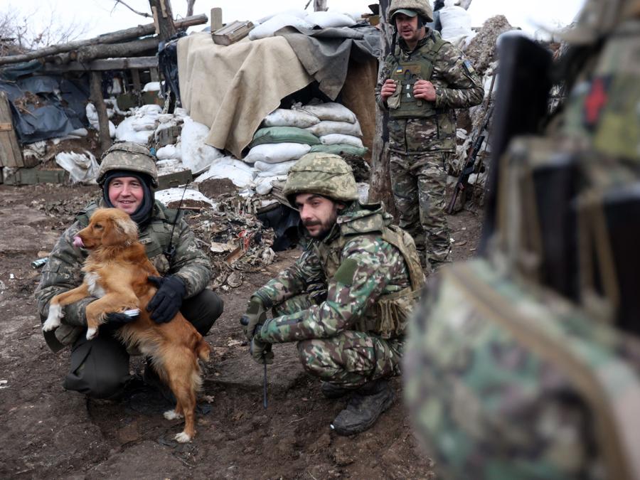 Alcuni militari ucraini, in compagnia di un cane, in una trincea in prima linea nella regione di Donetsk. (Photo by Anatolii Stepanov / AFP)