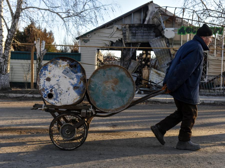 Un uomo  trasporta barili su un carro a Siversk, regione di Donetsk, Ucraina orientale. (EPA/Oleg Petrasyuk)