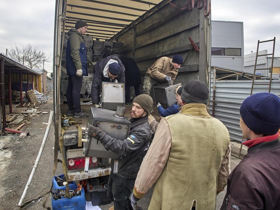  Volontari a Kharkiv scaricano 650 stufe a legna prodotte in Finlandia e inviate come aiuti umanitari. (EPA/Sergey Kozlov)