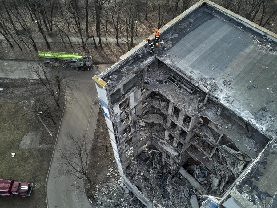 I soccorritori ucraini ripuliscono le macerie degli edifici danneggiati nel distretto settentrionale di Saltivka a Kharkiv. (EPA/Sergey Kozlov)