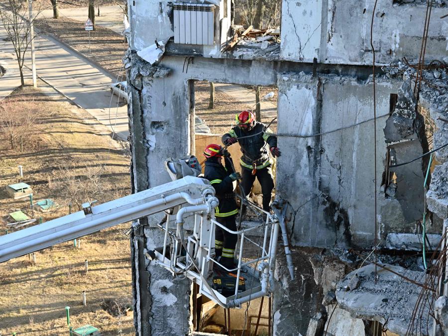 I costruttori rimuovono i detriti da un edificio residenziale durante i lavori di ristrutturazione di un condominio, parzialmente distrutto dai bombardamenti, nella periferia di Kharkiv. (Photo by Sergey Bobok / AFP)