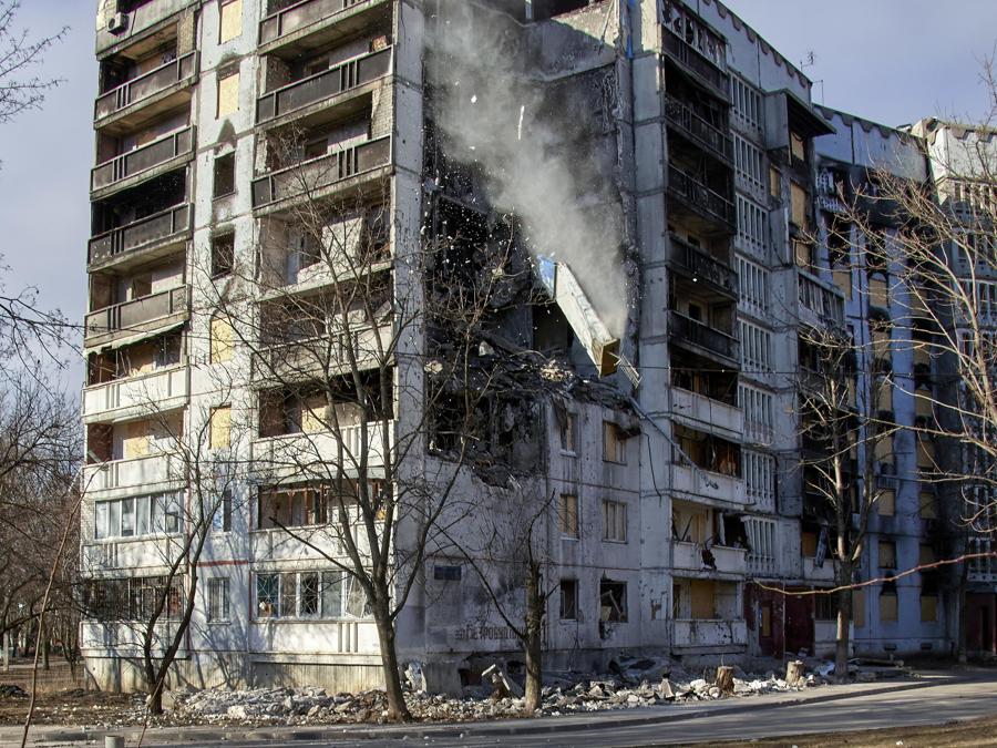 Soccorritori ucraini ripuliscono le macerie degli edifici residenziali danneggiati nel distretto settentrionale di Saltivka a Kharkiv. (EPA/Sergey Kozlov)