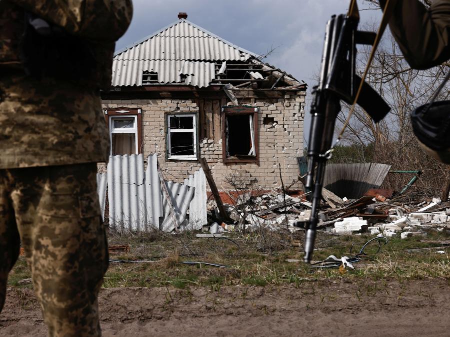 I militari ucraini accanto a un edificio distrutto vicino alla città in prima linea di Kreminna, durante l’attacco della Russia all’Ucraina, nella regione di Luhansk. REUTERS/Violeta Santos Moura