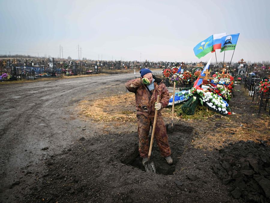 Un uomo scava una tomba vicino alle tombe dei soldati russi in un cimitero nella città di Yefremov, nella regione di Tula. (Photo by Natalia KOLESNIKOVA / AFP)