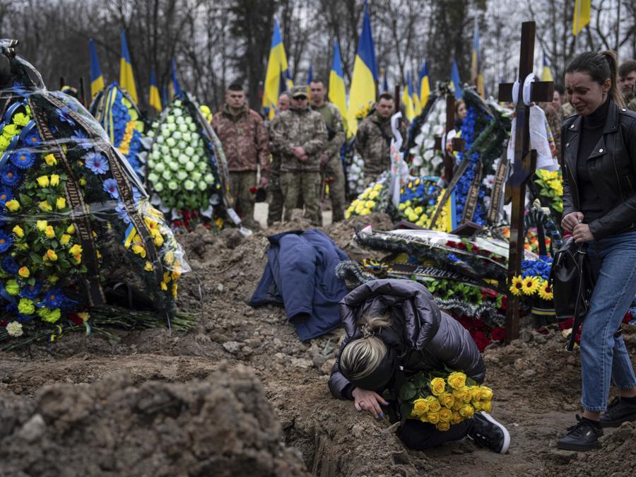 La moglie Natalia piange sulla tomba del marito e del militare ucraino Andrii Neshodovskiy durante la cerimonia funebre al cimitero di Kiev. (AP Photo/Evgeniy Maloletka)