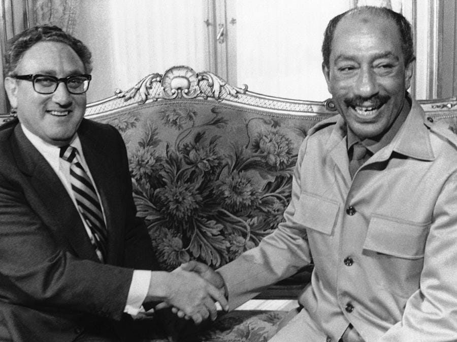 Il segretario di Stato Henry Kissinger stringe la mano al presidente egiziano Anwar Sadat al Palazzo Tahira al Cairo durante il loro incontro sulla crisi in Medio Oriente, 7 novembre 1973.  (Foto AP)