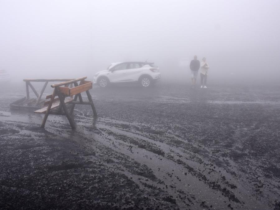 La ricaduta di copiosa cenere vulcanica a causa dell'attività eruttiva dell'Etna sul piazzale del Rifugio Sapienza, Nicolosi (Catania) (ANSA/ORIETTA SCARDINO)