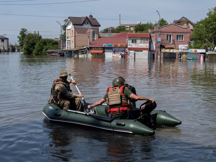 Forze di sicurezza ucraine evacuano i residenti da un’area allagata dopo la distruzione della diga di Kakhova. (Afp)