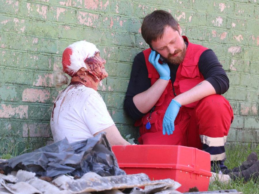 Un medico aiuta un residente ferito in un’area residenziale colpita da un attacco missilistico russo nella regione di Kiev. (Servizio stampa del Servizio di emergenza statale dell’Ucraina/dispensa tramite Reuters)