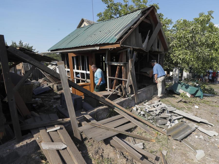 I residenti ispezionano i danni alla loro casa colpita dalla caduta di detriti da un razzo, nel villaggio di Stari Petrivtsi vicino a Kiev. (Epa/Sergey Dolzhenko)