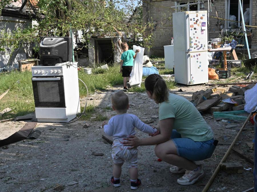 I residenti recuperano gli effetti personali dai resti della loro casa a seguito di un attacco missilistico russo nel villaggio di Stari Petrivtsi fuori Kiev. (Photo by Genya Savilov / Afp)