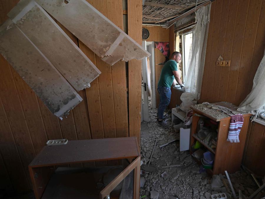 Un giovane uomo ispeziona la casa distrutta di sua madre a seguito di un attacco missilistico russo nel villaggio di Stari Petrivtsi fuori Kiev. (Photo by Genya Savilov / Afp)