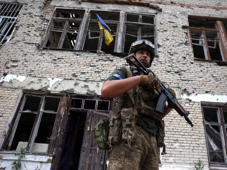 Un militare ucraino si trova di fronte a un centro culturale gravemente danneggiato nel villaggio recentemente liberato di Blagodatne, nella regione di Donetsk. (Photo by Anatolii Stepanov / Afp)