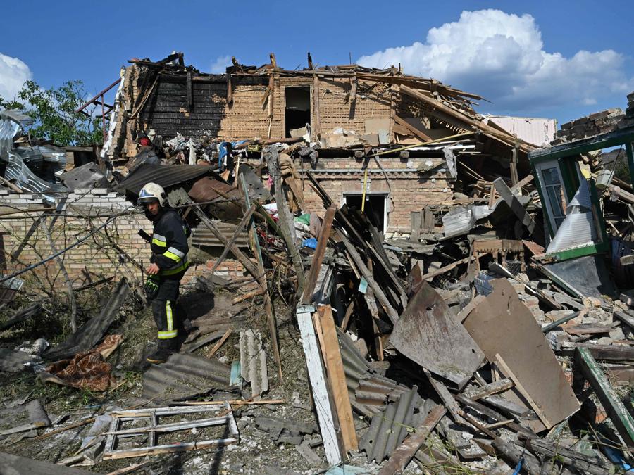 Un vigile del fuoco cammina tra i detriti di case distrutte a seguito di un attacco missilistico russo nel villaggio di Stari Petrivtsi fuori Kiev. (Photo by Genya Savilov / Afp)