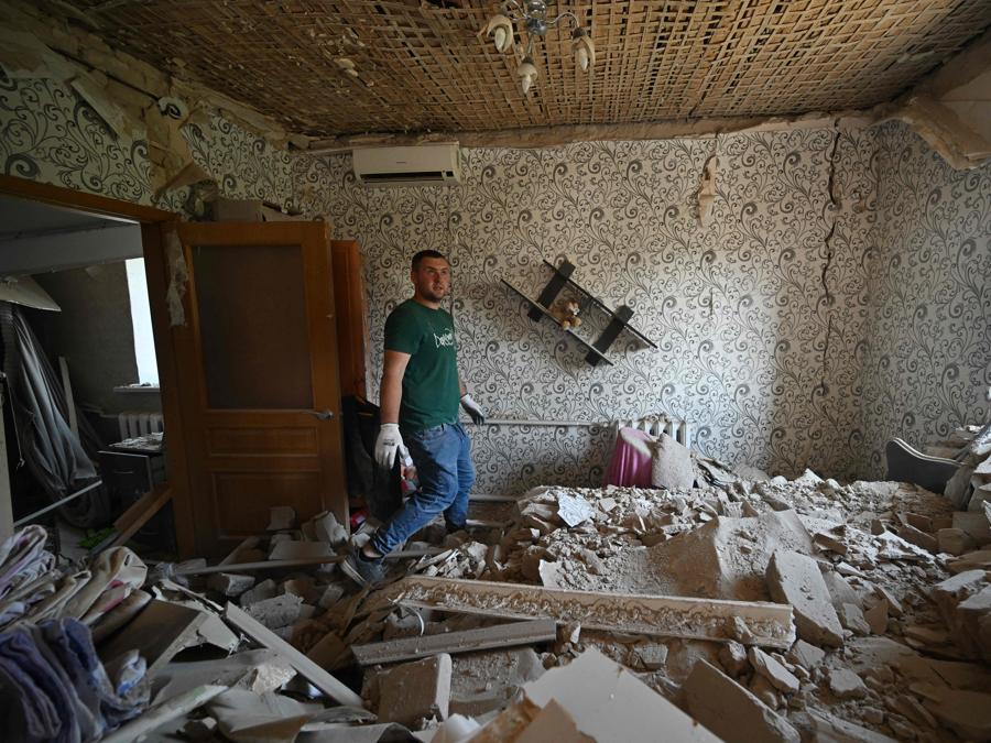 Un giovane uomo ispeziona la casa distrutta di sua madre a seguito di un attacco missilistico russo nel villaggio di Stari Petrivtsi fuori Kiev. (Photo by Genya Savilov / Afp)