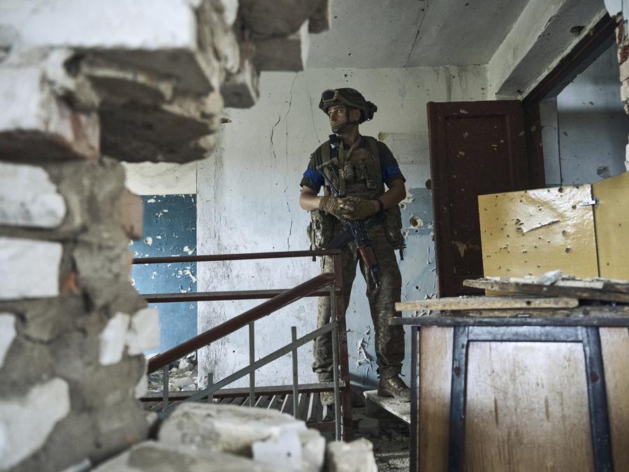 Un soldato ucraino esamina un centro culturale a Blahodatne, regione di Donetsk. (AP Photo/Libkos)