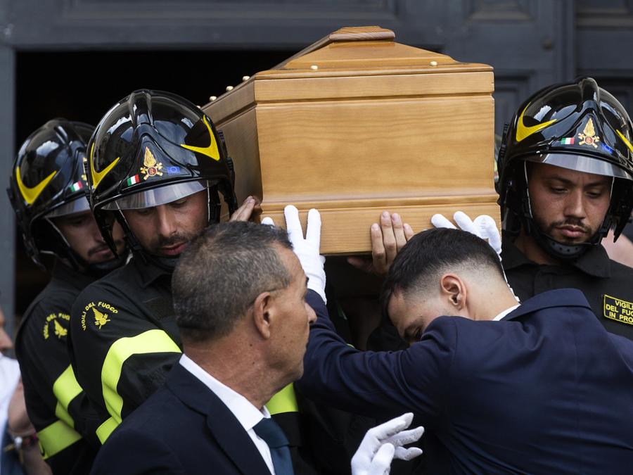 A portare il feretro in chiesa è un picchetto dei Vigili del fuoco: il perché lo ha spiegato Edoardo Purgatori, che ha reso omaggio al padre insieme al fratello e la sorella a fine cerimonia. “Una delle prime telefonate che ho ricevuto è stata quella di Piero Moscardini - ha raccontato - che aveva conosciuto papà tanti anni fa, quando lui da cronista passava tanto tempo nelle caserme. Mi ha chiesto l’onore di far portare papà ai vigili del fuoco”.  (Ansa/Angelo Carconi)