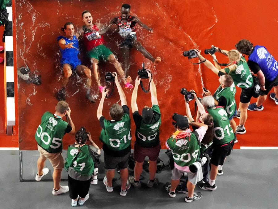 Gianmarco Tamberi, medaglia d’oro italiana nel salto in alto maschile, Soufiane El Bakkali, medaglia d’oro marocchina e Abraham Kibiwot, medaglia di bronzo keniana, nella corsa a ostacoli maschile di 3000 metri, festeggiano dopo le finali. (Reuters/Fabrizio Bensch)
