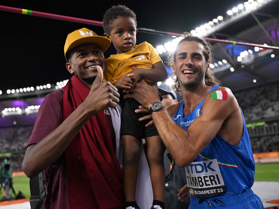 Gianmarco Tamberi (a destra), primo classificato, festeggia con Mutaz Essa Barshim, terzo classificato del Qatar, e suo figlio dopo aver gareggiato nella finale di salto in alto maschile durante i Campionati mondiali di atletica leggera al Centro nazionale di atletica leggera di Budapest. (Photo by Kirill Kudryavtsev / Afp)