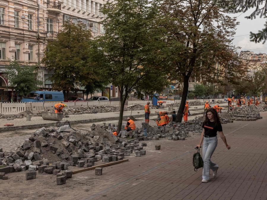 I lavoratori comunali riparano una strada di ciottoli nel centro di Kiev. (Photo by Roman PILIPEY / AFP)