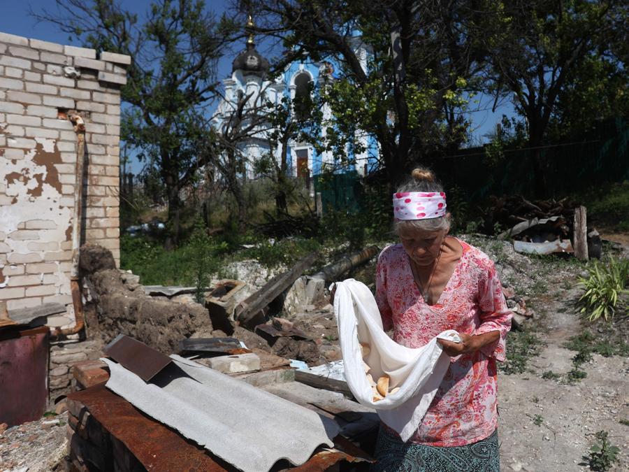 La residente locale Lyubov Doroshenko, asciuga il pane fuori dalla sua casa, che è stata distrutta durante la guerra, nel villaggio di Bohorodychne, nella regione di Donetsk. (Photo by Anatolii Stepanov / AFP)