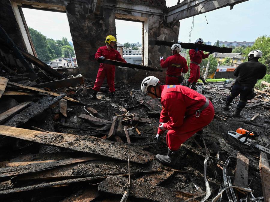 I soccorritori rimuovono i detriti dopo che un drone ha colpito un istituto scolastico, a Kharkiv. (Photo by Sergey Bobok / Afp)