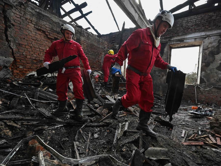 I soccorritori rimuovono i detriti dopo che un drone ha colpito un istituto scolastico, a Kharkiv. (Photo by Sergey Bobok / Afp)