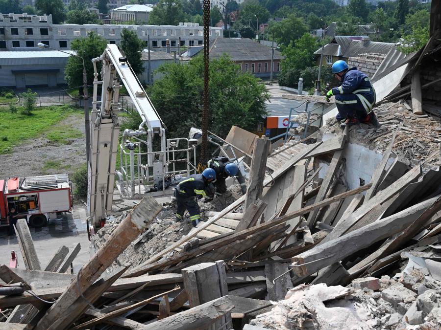 I soccorritori ucraini rimuovono i detriti dopo che un drone ha colpito un istituto scolastico, a Kharkiv. (Photo by Sergey Bobok / Afp)