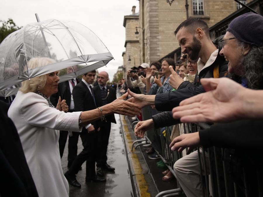 La regina Camilla della Gran Bretagna incontra i residenti dopo aver visitato il mercato dei fiori giovedì.(AP Photo/Christophe Ena; Pool)
