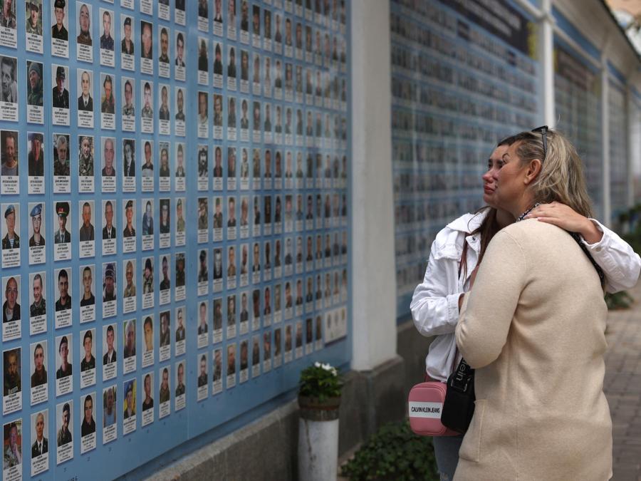 Le persone visitano il Muro della memoria dei difensori caduti dell’Ucraina a Kiev. (Photo by Anatolii STEPANOV / AFP)