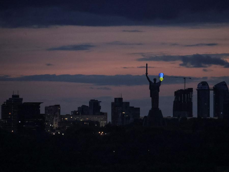 L’emblema nazionale ucraino sullo scudo del monumento “Patria” è illuminato con i colori della bandiera ucraina per celebrare la Giornata dei difensori dell’Ucraina, nel mezzo dell’attacco russo all’Ucraina, a Kiev. (REUTERS/Yevhen Kotenko)