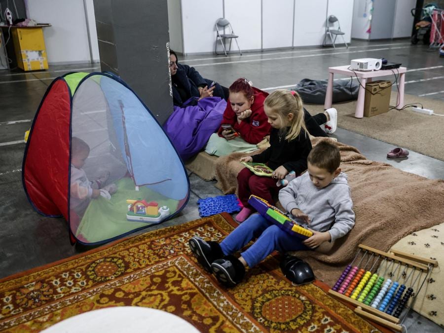 Alcune madri con figli nell’area giochi del rifugio per sfollati a Zaporizhia. La loro casa a Kushuhum è stato distrutto da un attacco russo. (Epa/Kateryna Klochko)