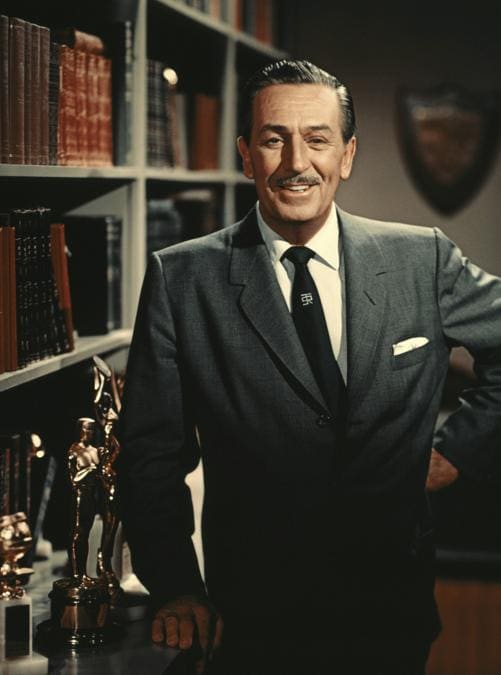 Walt Disney posa accanto alla statua dell’Oscar nel suo ufficio nel 1960 . (Photo by Screen Archives/Getty Images).