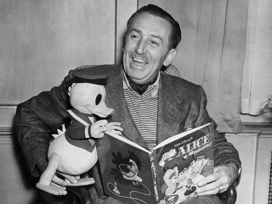 Walt Disney con un giocattolo di Paperino che legge Alice nel Paese delle Meraviglie, 1951. (Photo by © Hulton-Deutsch Collection/CORBIS/Corbis via Getty Images)