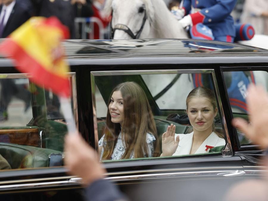 La principessa ereditaria spagnola delle Asturie Leonor saluta dalla sua auto accanto alla principessa spagnola Sofia mentre si reca al Congresso dei deputati per giurare fedeltà alla costituzione, nel giorno del suo 18esimo compleanno. (Photo by Oscar Del Pozo / Afp)