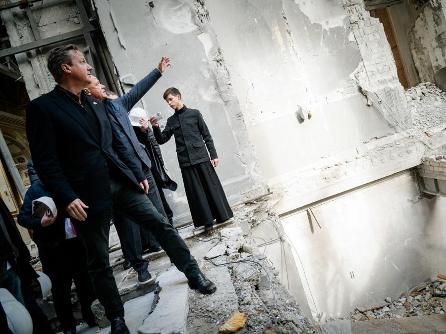 Il ministro degli Esteri britannico David Cameron visita una chiesa danneggiata dai bombardamenti russi. (EPA)
