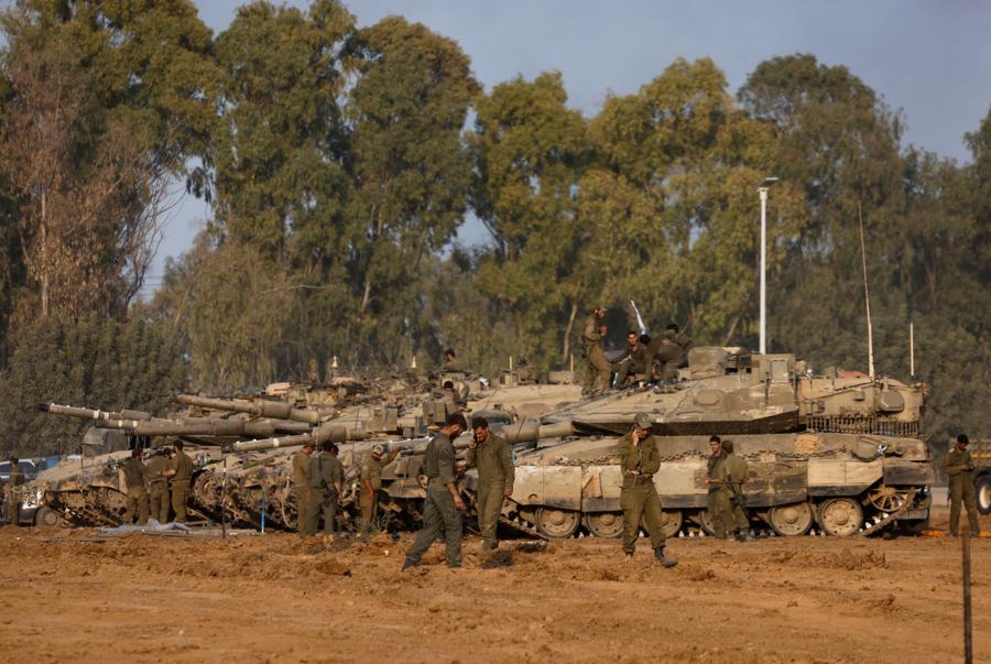 Soldati israeliani accanto ai carri armati, dopo essere tornati dall’operazione di terra in corso a Gaza. (Reuters)