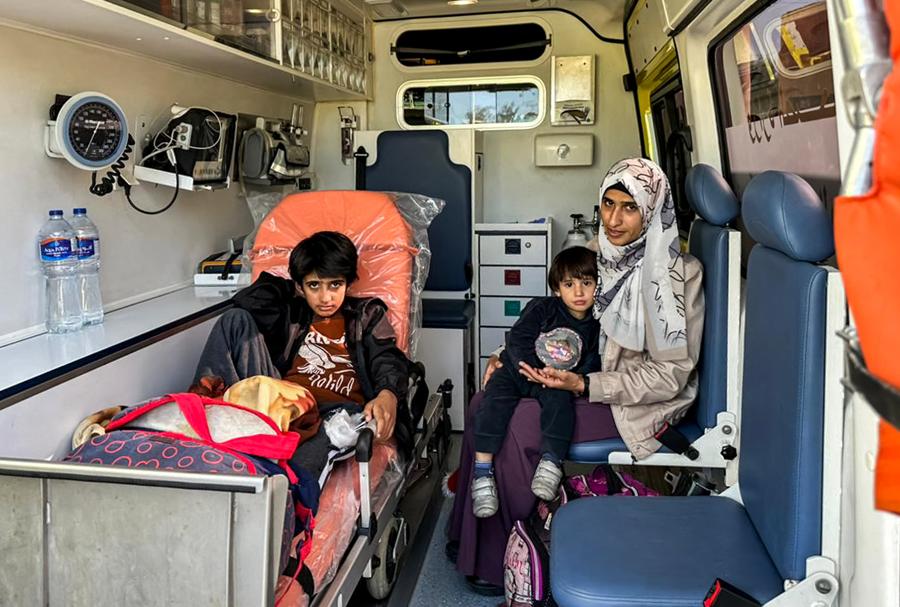 Una donna siede con i suoi figli in un’ambulanza dopo essere stata evacuata con altri palestinesi dalla Striscia di Gaza al valico di frontiera di Rafah, nel nord-est dell’Egitto.  (AFP)