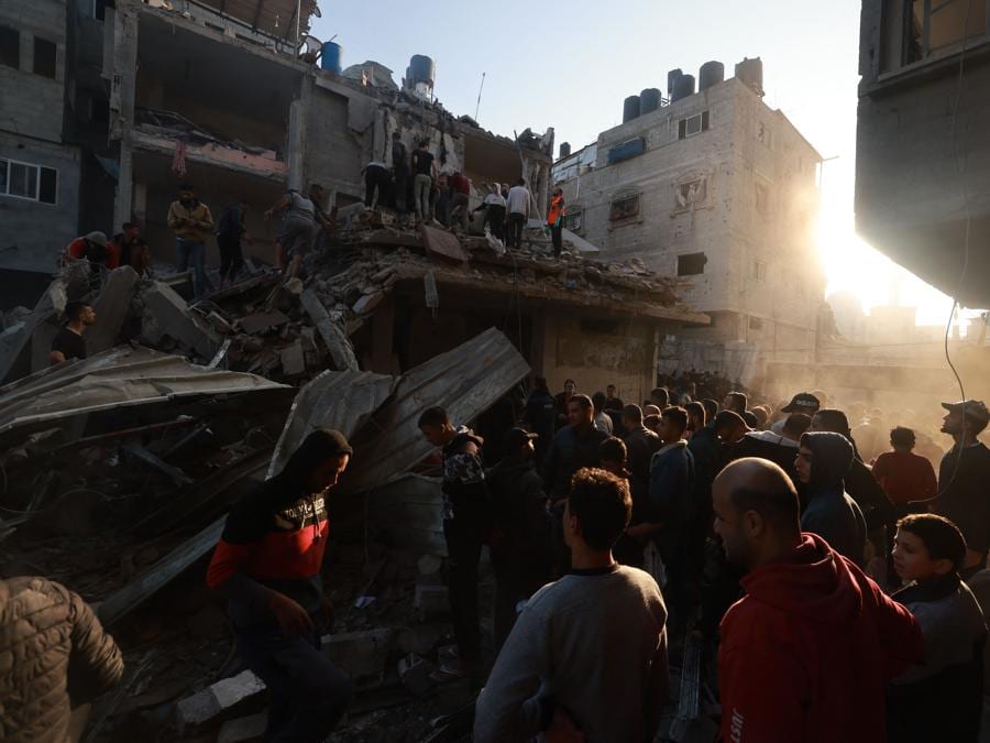 Palestinesi osservano la distruzione a seguito di un attacco aereo israeliano sul campo profughi di Rafah, nel sud della Striscia di Gaza. (Photo by MOHAMMED ABED / AFP)